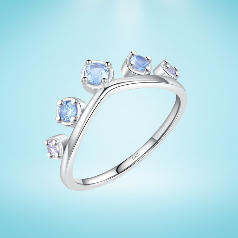 Sterling silver ring with six graduated light blue and lavender stones set in a tiara-like arc

