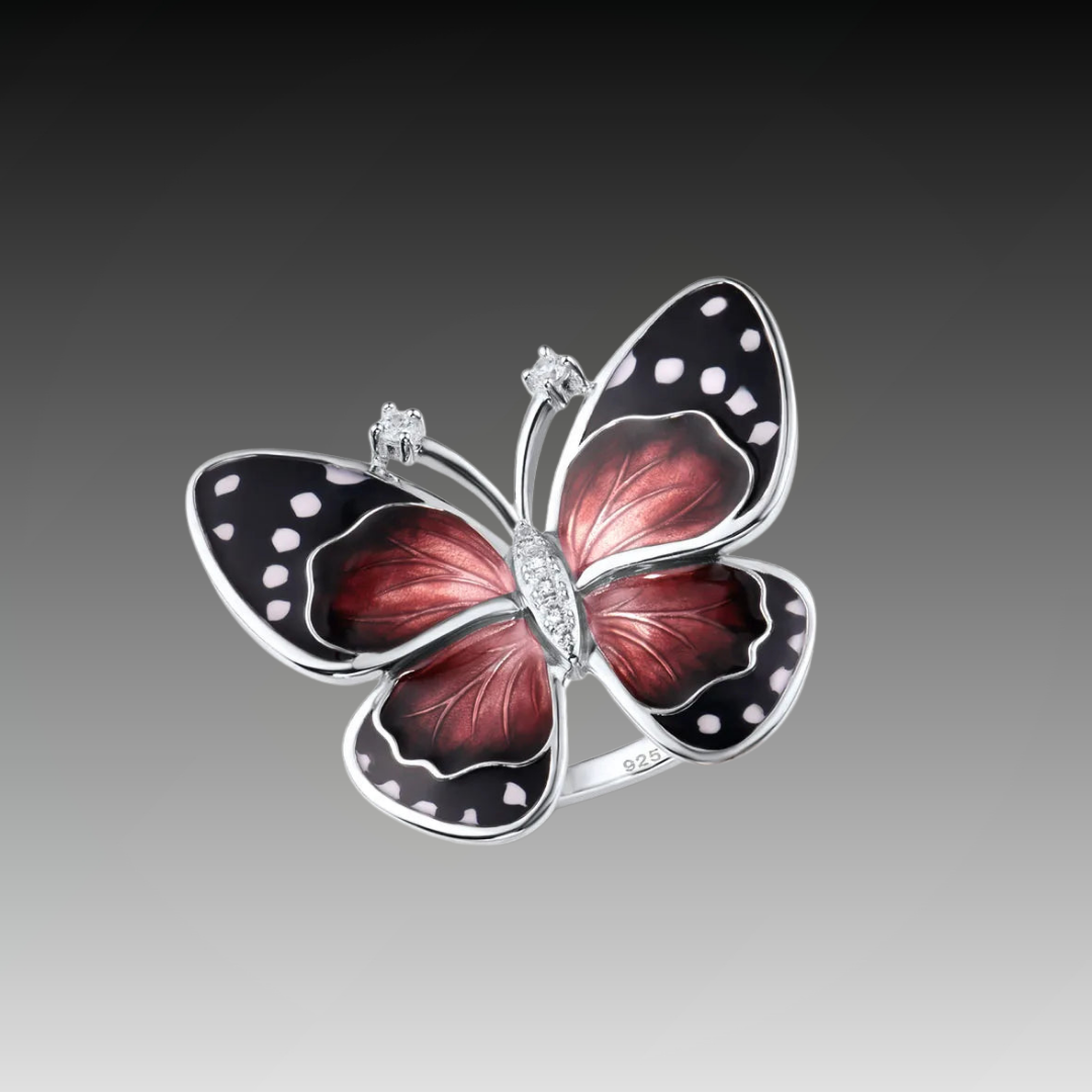 Butterfly-inspired ring with red enamel wings, black accents, and white dot details.

