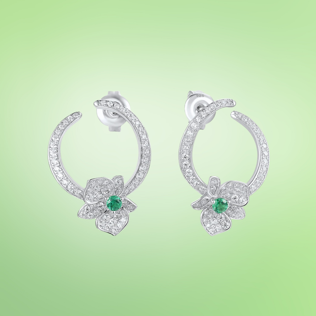 Silver stud earrings with open circle design, pavé stones, and green gemstone floral accents

