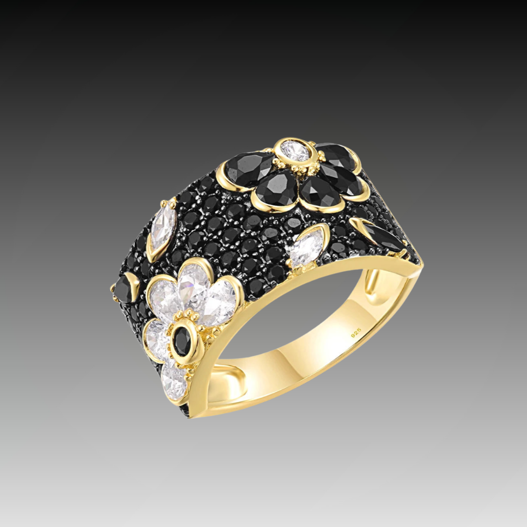 Wide gold-tone ring with black and white floral gemstone detailing

