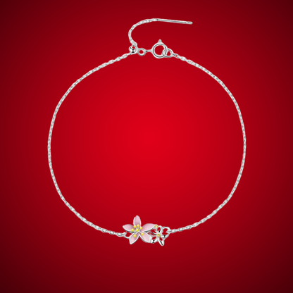 Delicate silver bracelet featuring two small pink cherry blossom charms on a fine chain.

