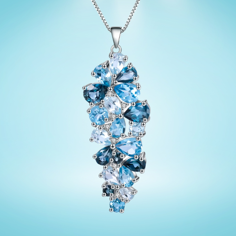 Silver pendant featuring a cascading cluster of mixed-cut blue gemstones in varying tones

