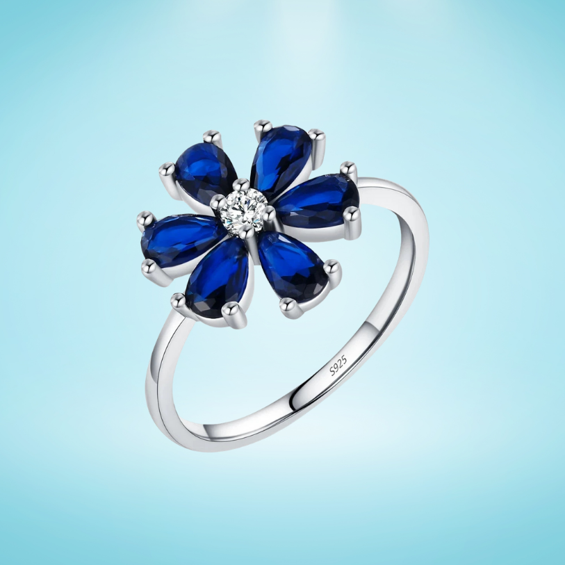 Sterling silver ring with a royal blue gemstone flower and clear stone center

