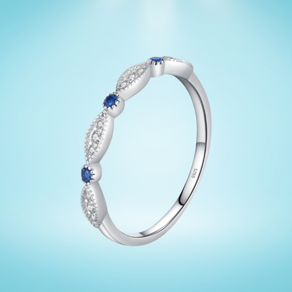 Sterling silver band with alternating marquise shapes and small round blue and clear stones

