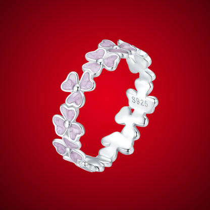 Delicate silver ring featuring small pink enamel flowers in a continuous garland design


