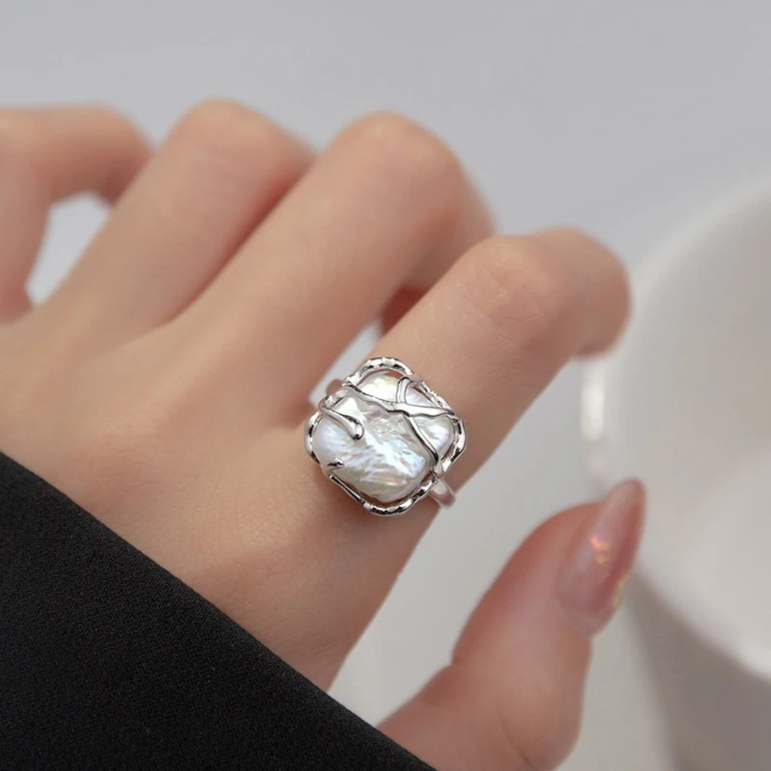 Sterling silver ring featuring a baroque freshwater pearl encased in an abstract organic claw setting

