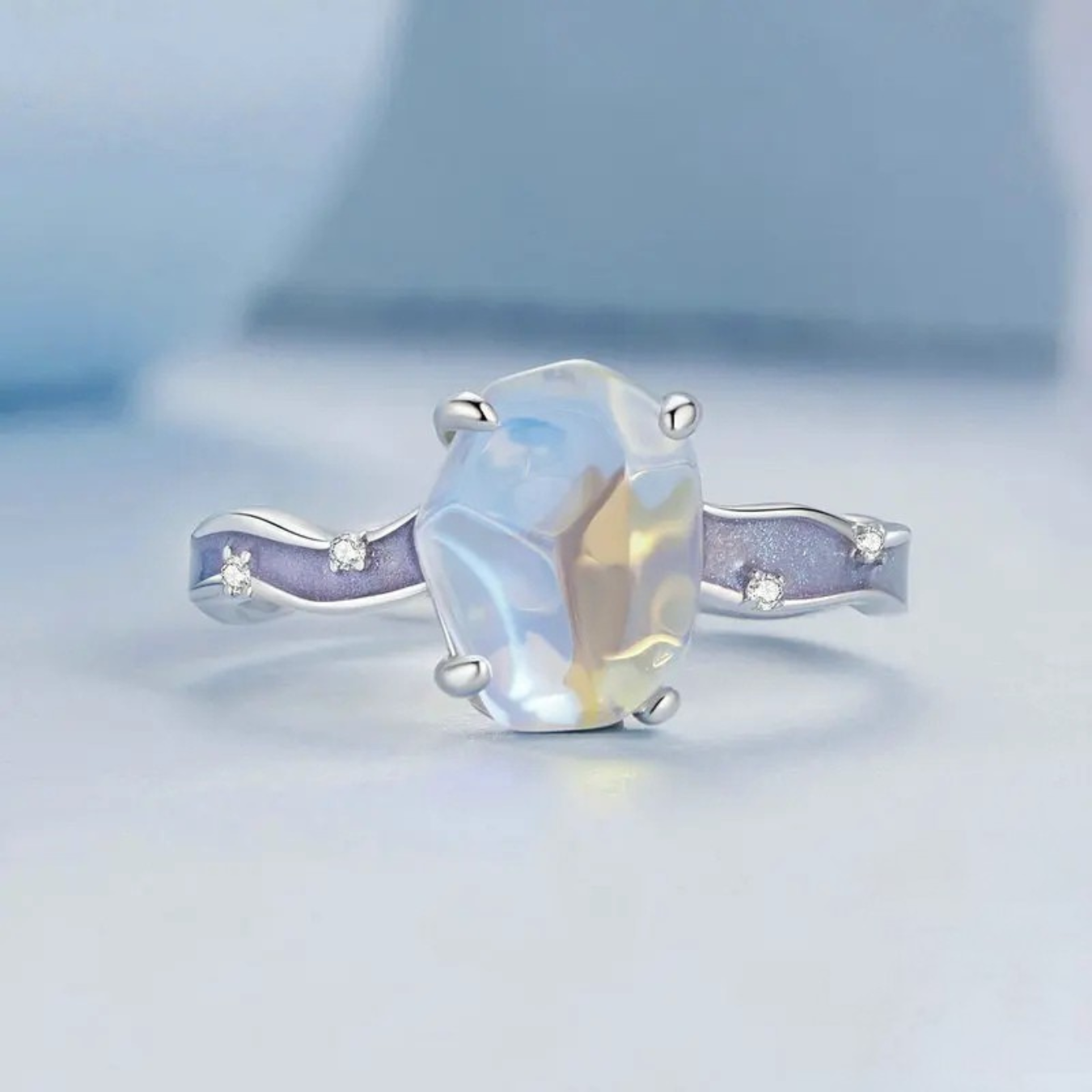 Ring with a large central gemstone and smaller stones on a light blue background