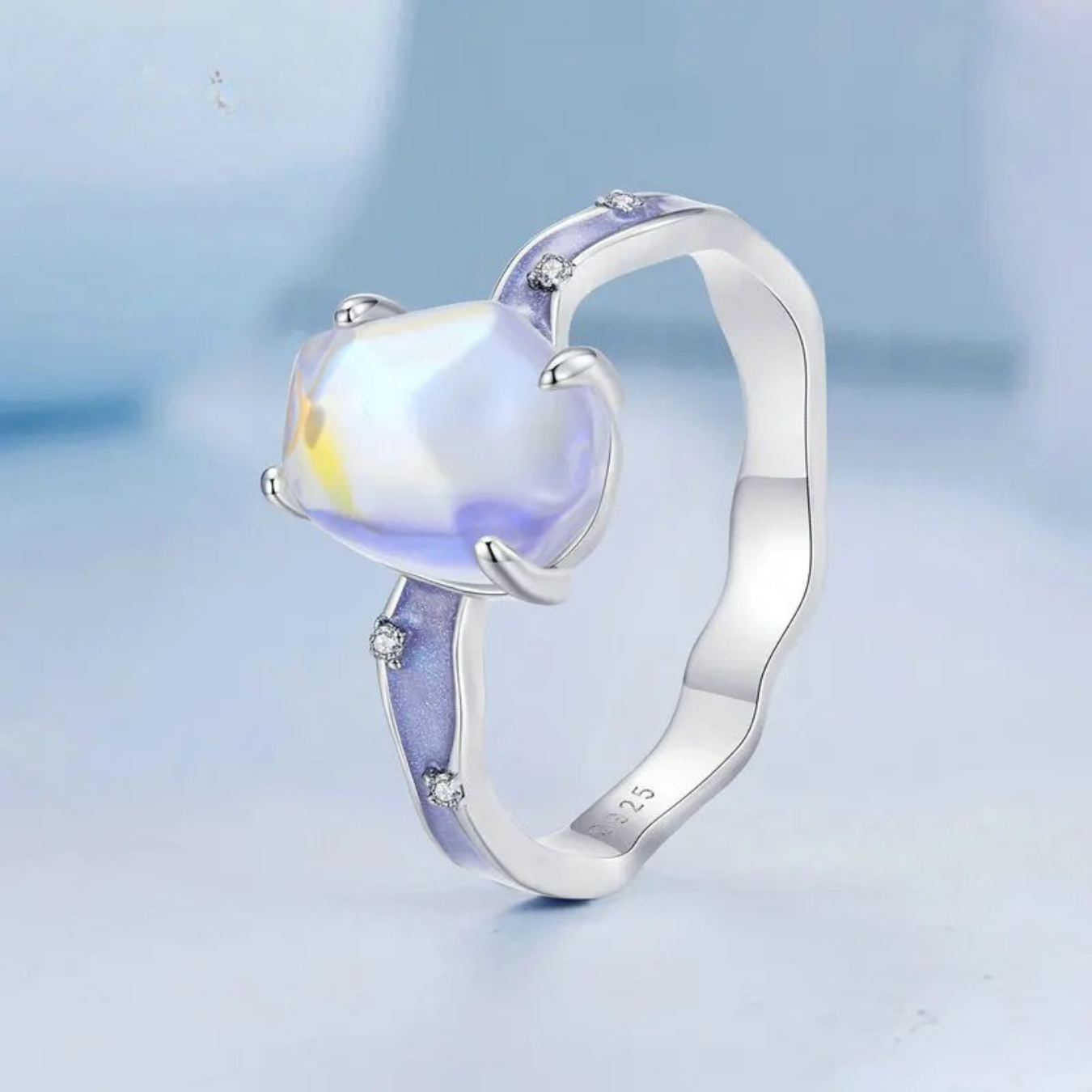 Silver ring with a heart-shaped gemstone on a light blue background