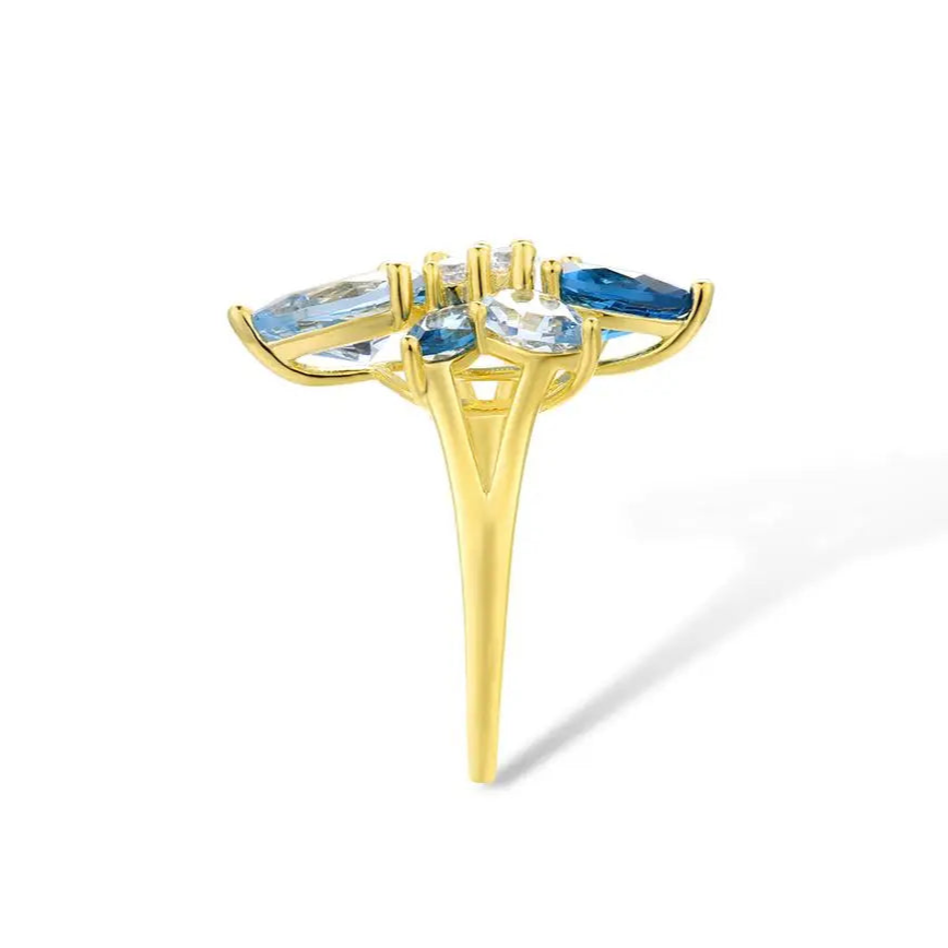Gold-plated ring with a cluster of blue and clear gemstones in marquise and pear cuts arranged like flower petals

