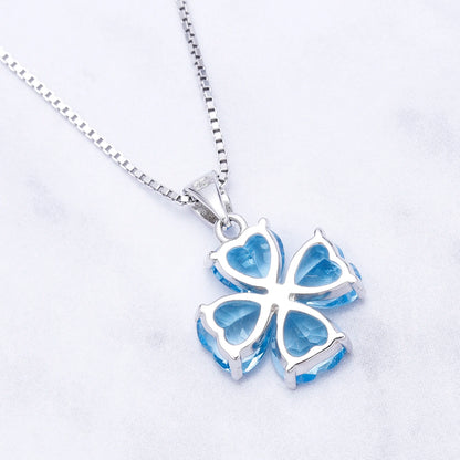 Silver pendant featuring four heart-cut light blue stones arranged in a floral shape

