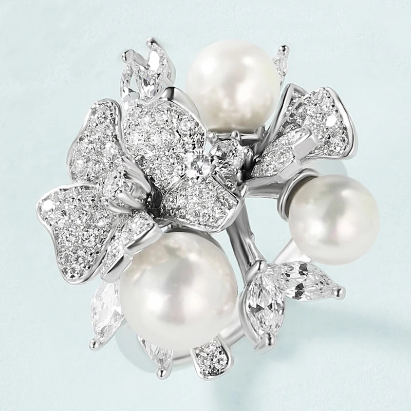 Jewellery set with white pearls and pavé floral details including earrings, brooch and pendant

