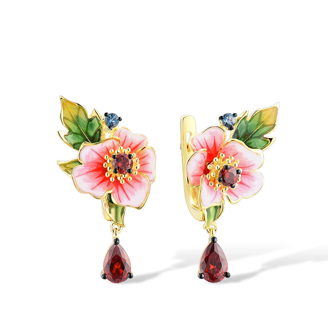 Amaryllis jewelry set with pink enamel flowers, red teardrop stones, green leaf accents, and small blue gemstones on a gold base.

