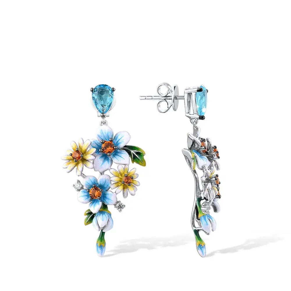 Sterling silver floral drop earrings with blue enamel flowers and orange gemstone centers

