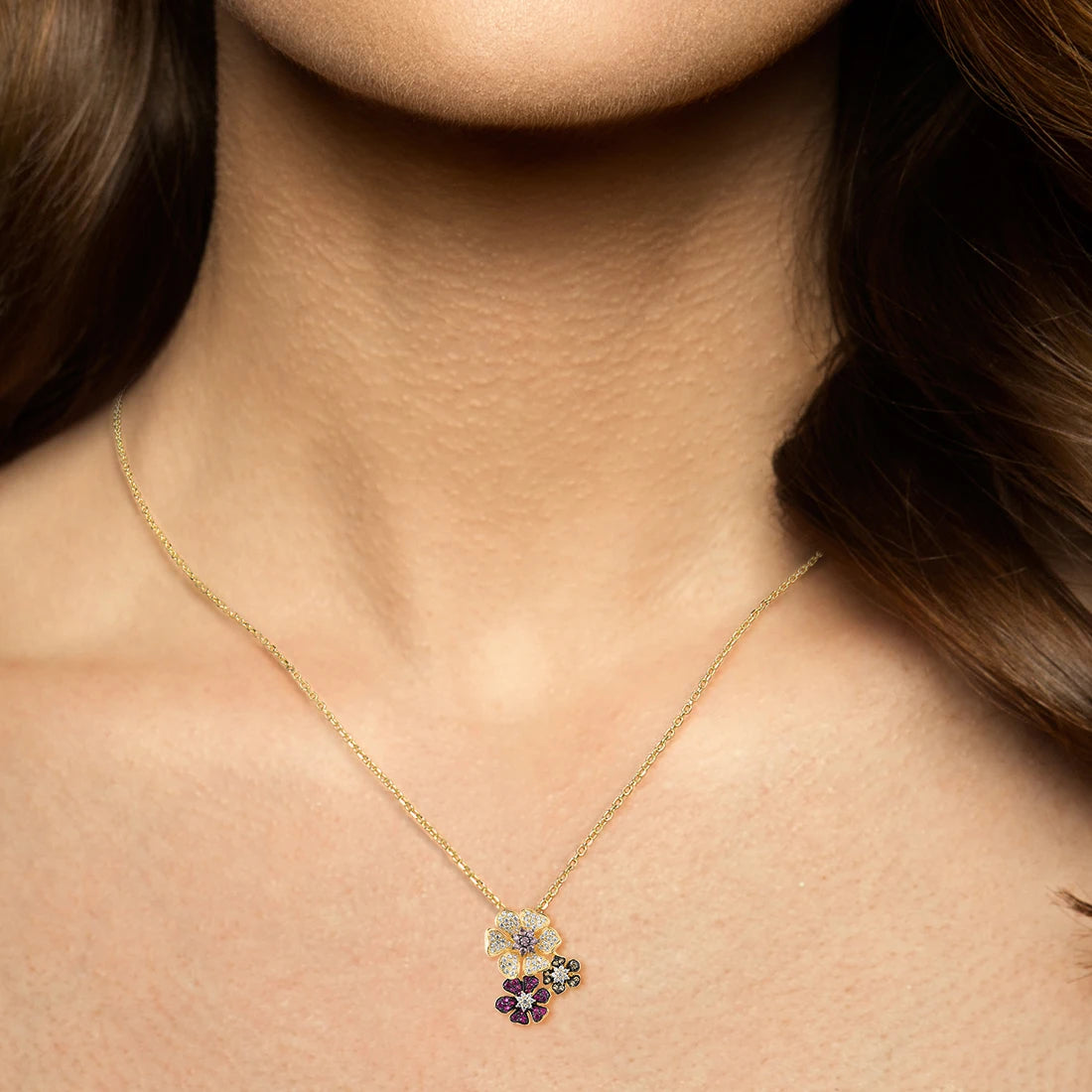 Clustered flower-shaped pendant with white, pink, red, and black pavé stones in gold-toned settings



