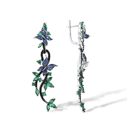 Long silver earrings with blue and green crystal butterflies and vine-like detailing

