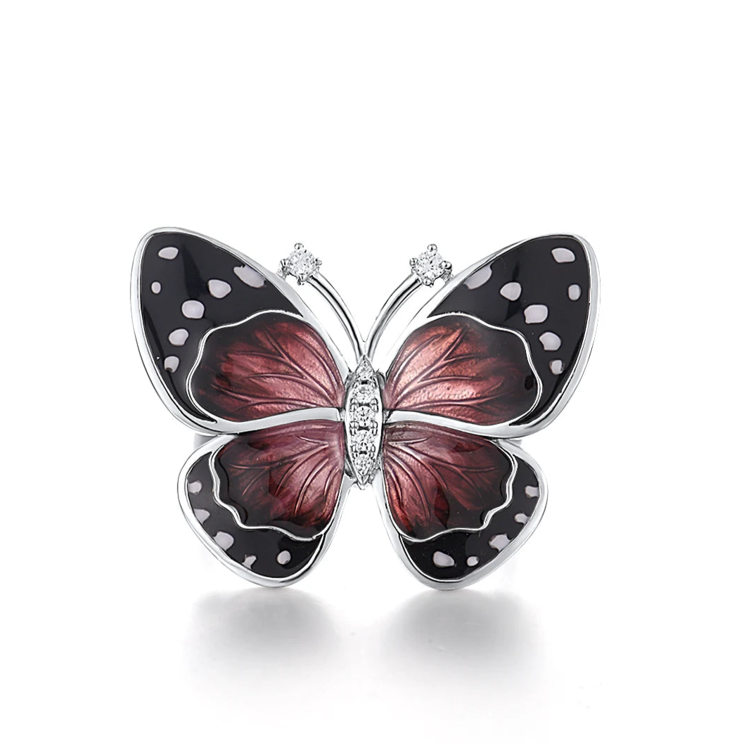 Butterfly-inspired ring with red enamel wings, black accents, and white dot details.

