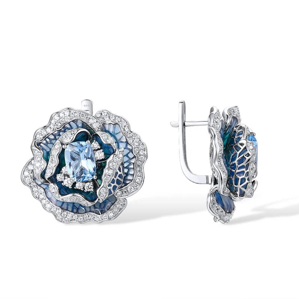 Silver and blue enamel rose-shaped earrings with layered petals and central light blue gemstones


