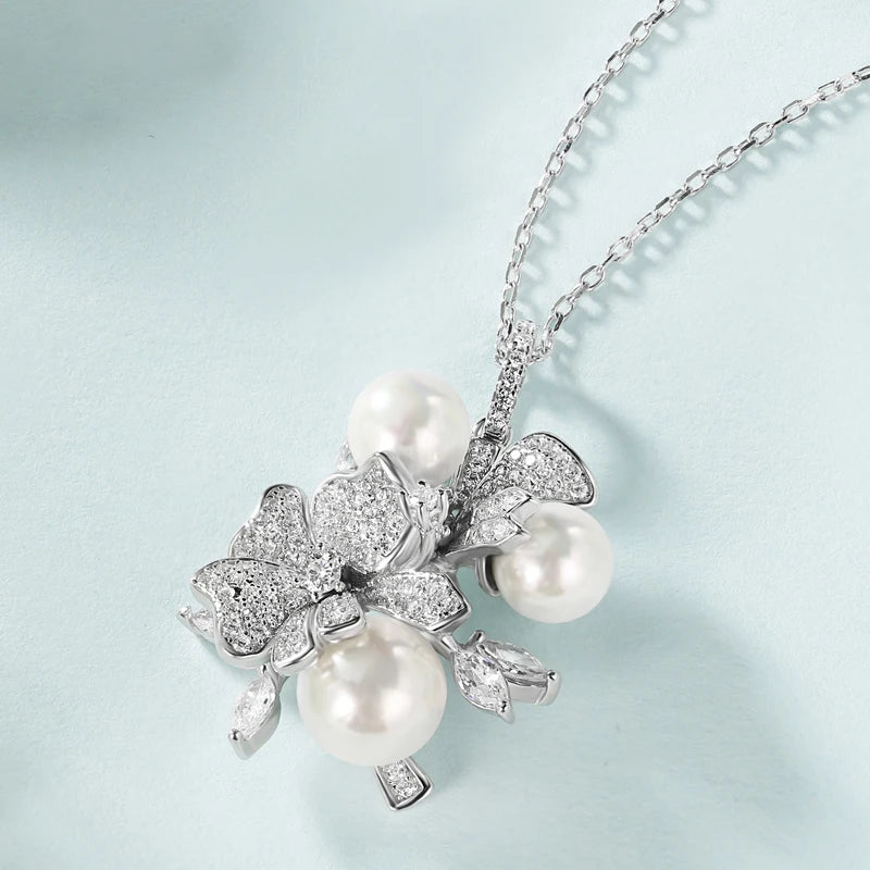 Jewellery set with white pearls and pavé floral details including earrings, brooch and pendant

