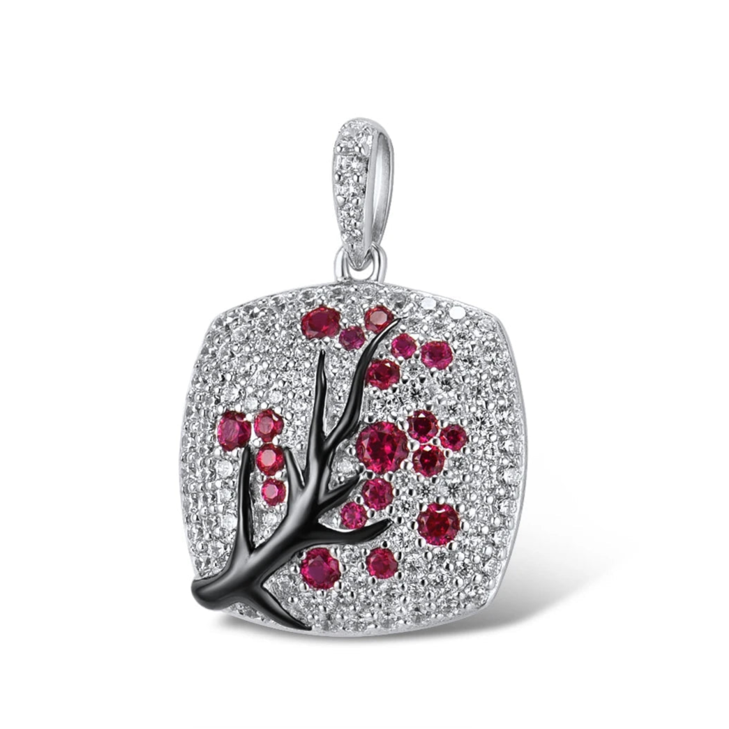 Square silver pendant featuring a black branch with red stones arranged like blossoms.

