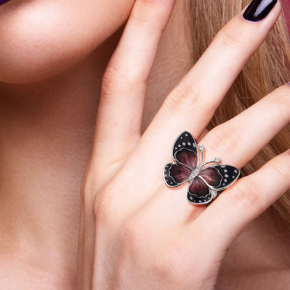 Butterfly-inspired ring with red enamel wings, black accents, and white dot details.

