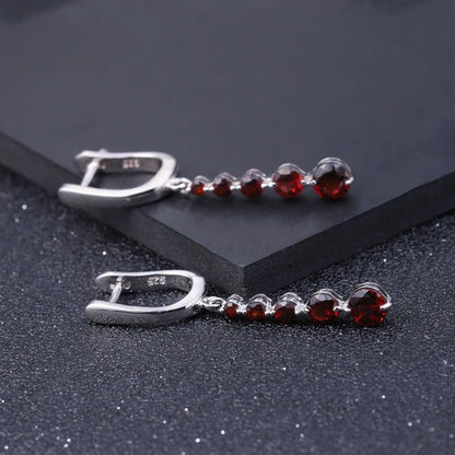 Silver drop earrings featuring a vertical cascade of five round garnet-red stones, from the Rossa Collection.

