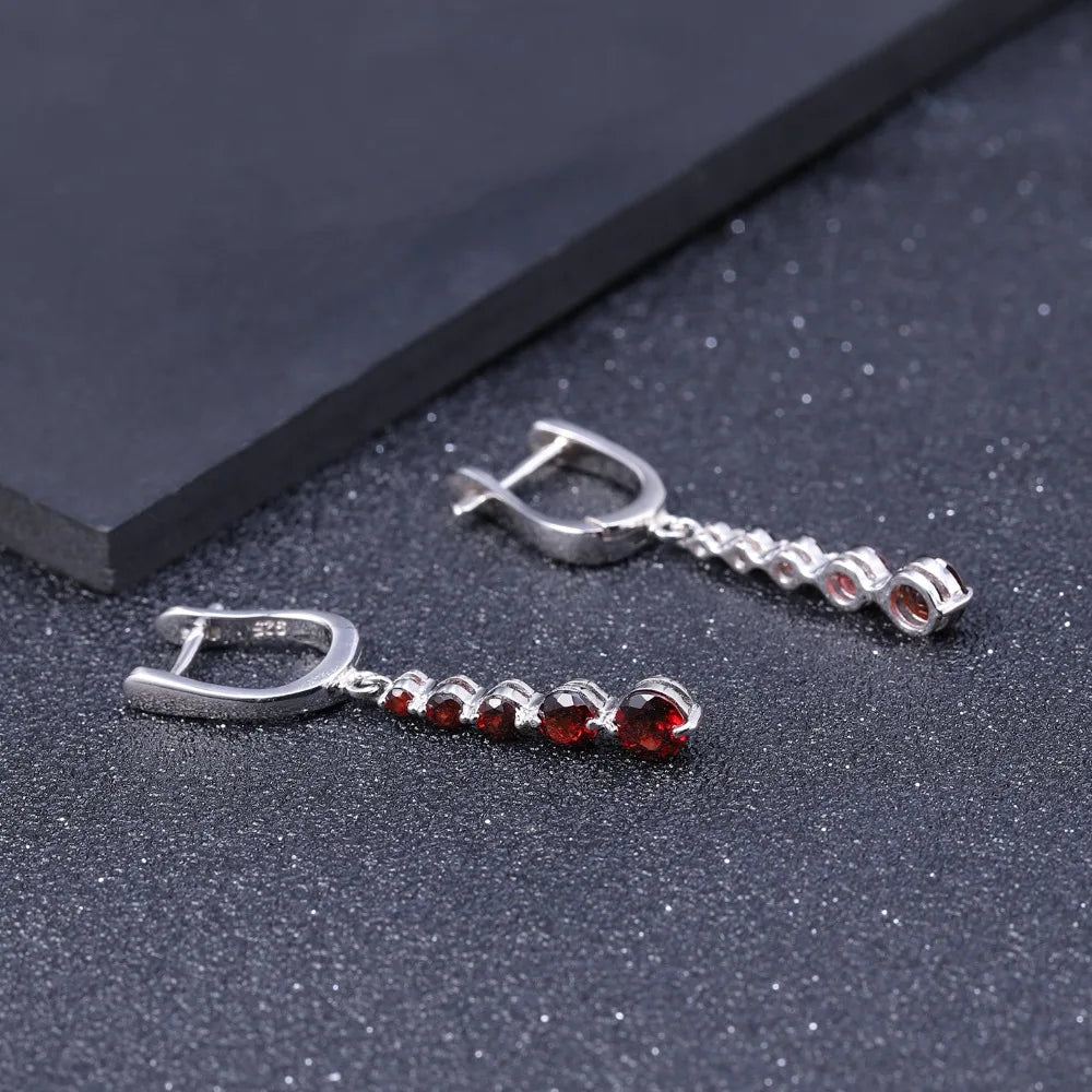 Silver drop earrings featuring a vertical cascade of five round garnet-red stones, from the Rossa Collection.

