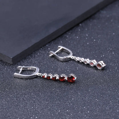 Silver drop earrings featuring a vertical cascade of five round garnet-red stones, from the Rossa Collection.

