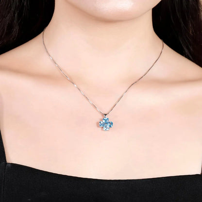 Silver pendant featuring four heart-cut light blue stones arranged in a floral shape

