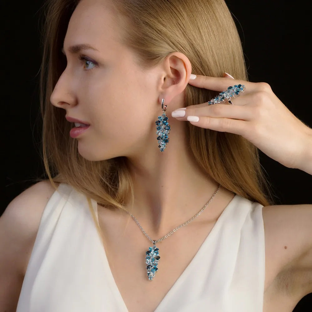 Silver pendant featuring a cascading cluster of mixed-cut blue gemstones in varying tones

