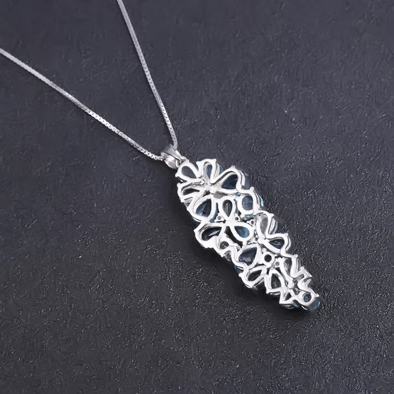 Silver pendant featuring a cascading cluster of mixed-cut blue gemstones in varying tones

