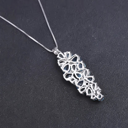 Silver pendant featuring a cascading cluster of mixed-cut blue gemstones in varying tones

