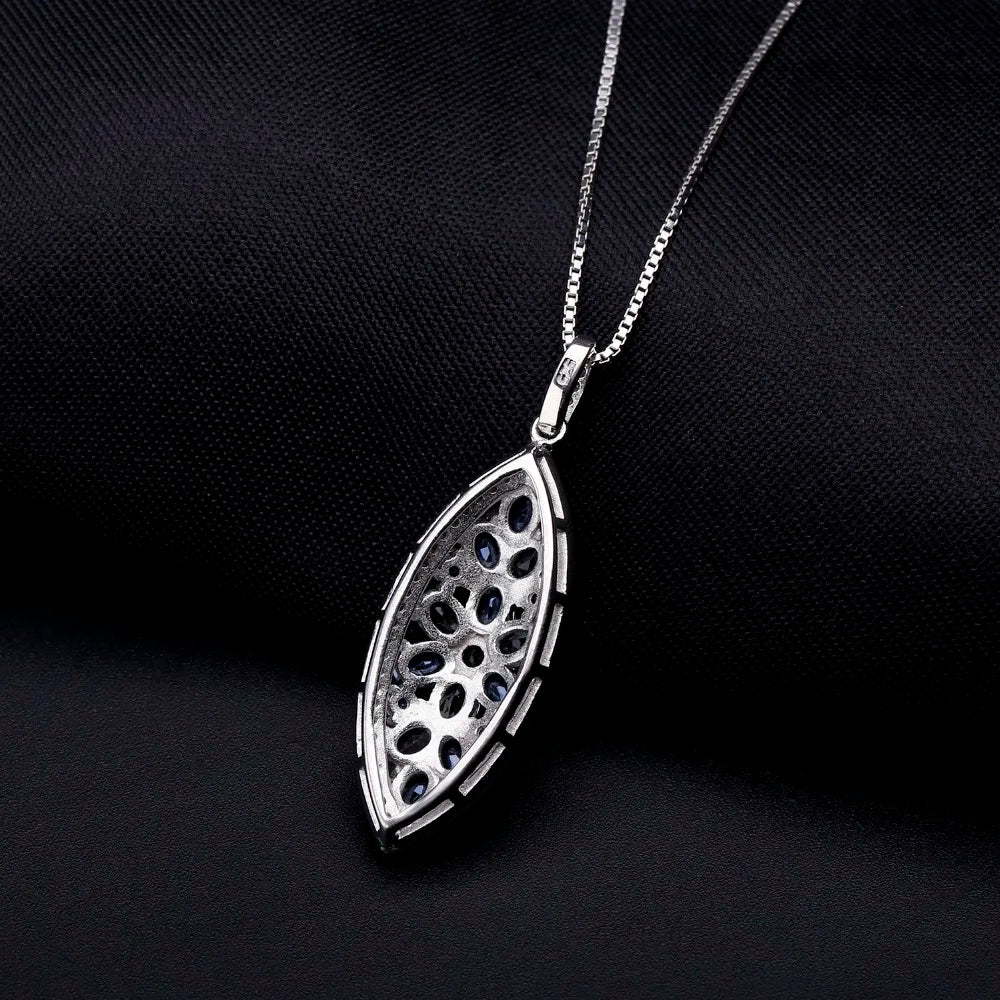 Marquise-shaped silver pendant with a floral arrangement of light and dark blue gemstones

