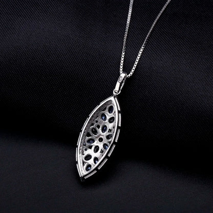 Marquise-shaped silver pendant with a floral arrangement of light and dark blue gemstones

