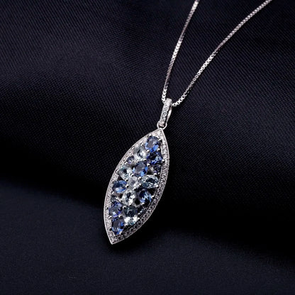 Marquise-shaped silver pendant with a floral arrangement of light and dark blue gemstones

