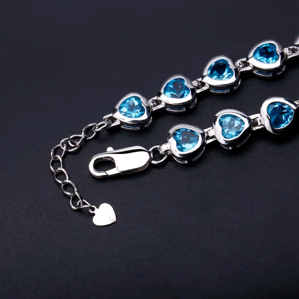Silver bracelet with heart-shaped blue stones in a linked design

