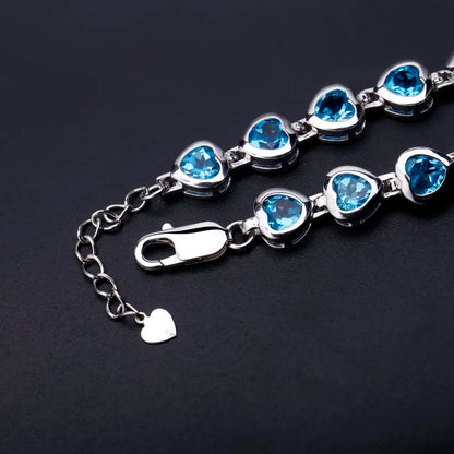 Silver bracelet with heart-shaped blue stones in a linked design

