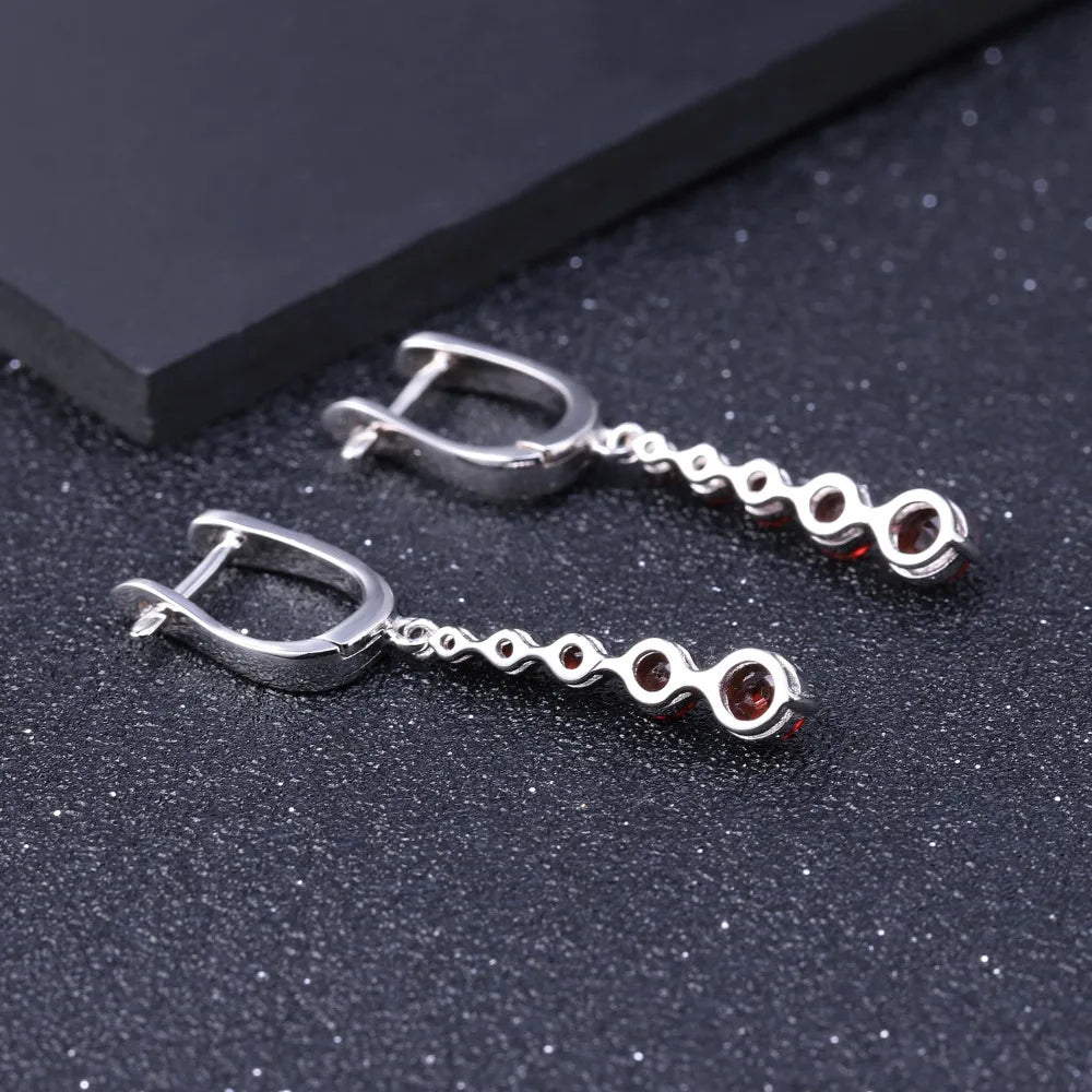 Silver drop earrings featuring a vertical cascade of five round garnet-red stones, from the Rossa Collection.

