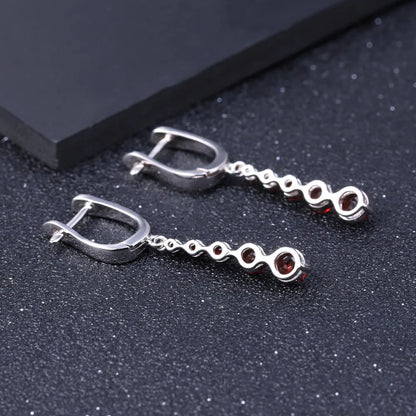 Silver drop earrings featuring a vertical cascade of five round garnet-red stones, from the Rossa Collection.

