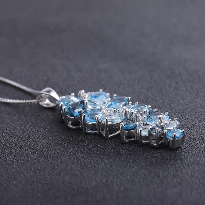 Silver pendant featuring a cascading cluster of mixed-cut blue gemstones in varying tones

