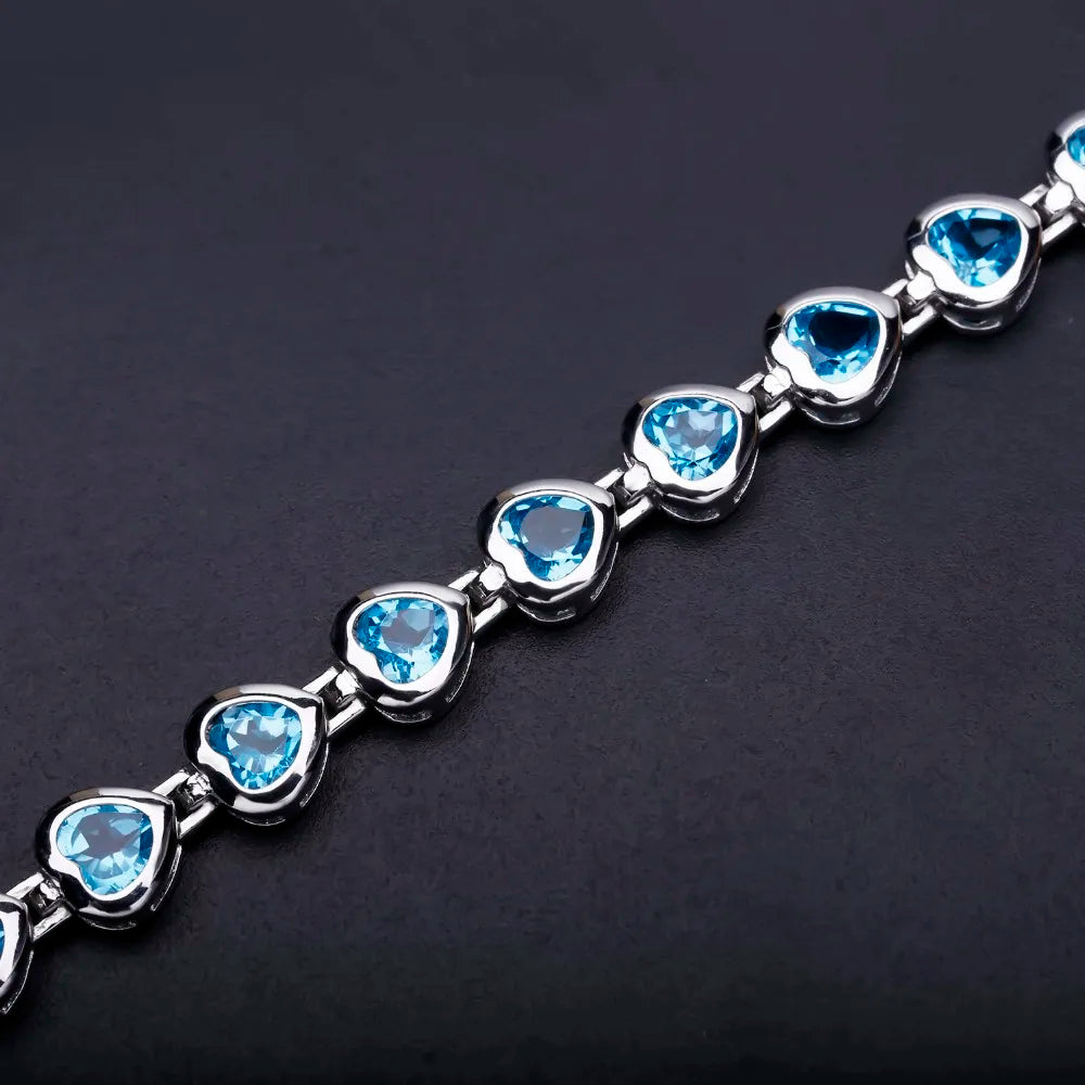 Silver bracelet with heart-shaped blue stones in a linked design

