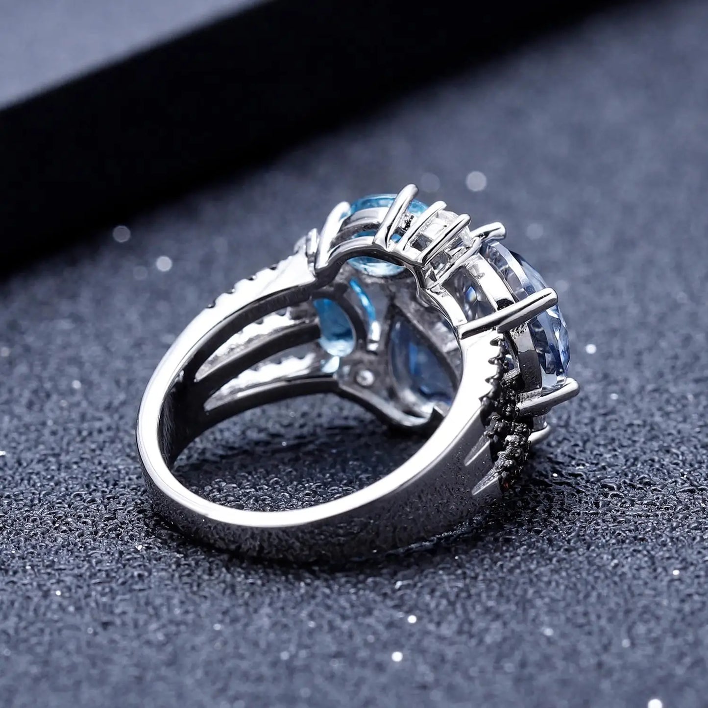 Silver ring featuring an asymmetric cluster of blue and violet gemstones in various cuts

