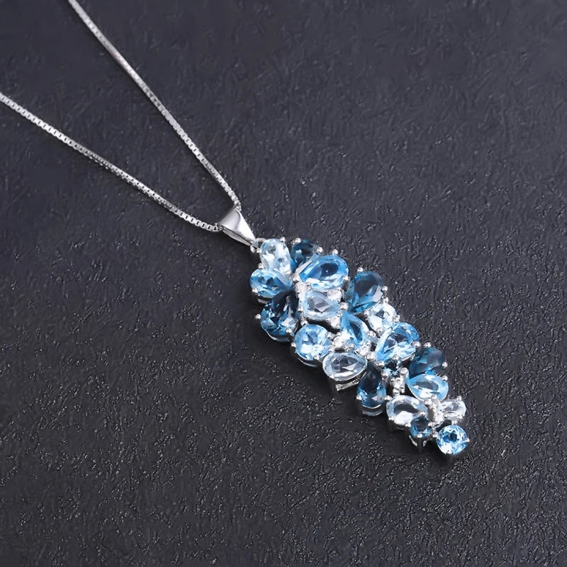 Silver pendant featuring a cascading cluster of mixed-cut blue gemstones in varying tones

