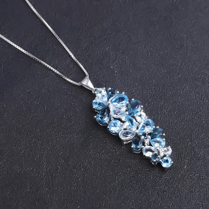 Silver pendant featuring a cascading cluster of mixed-cut blue gemstones in varying tones

