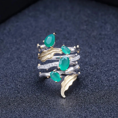 Multi-band silver ring with green gemstones, gold leaf accents, and intricate vine-like detailing

