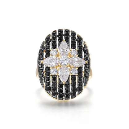 Gold ring with an oval black and white starburst design featuring clear marquise and round stones

