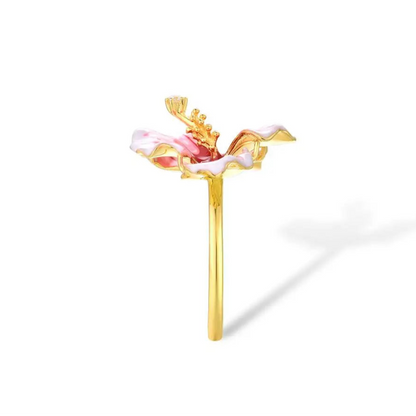 Prato ring shaped like a blooming hibiscus flower in pink enamel with golden stamen and a single sparkling white stone.

