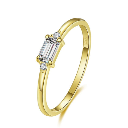 Delicate gold ring with a rectangular light green stone and two small clear side stones.

