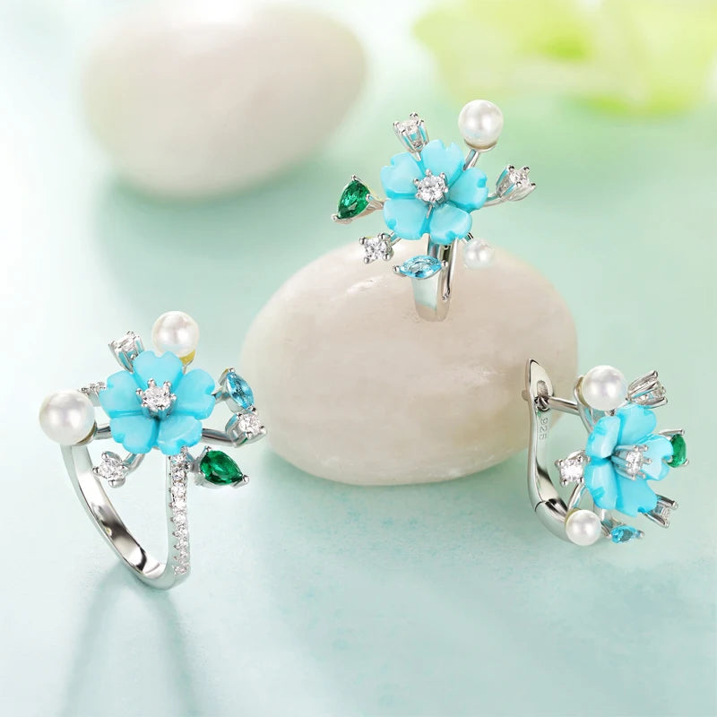 Turquoise flower jewelry set with pearls, green and blue gemstones, and white zircon accents on silver.

