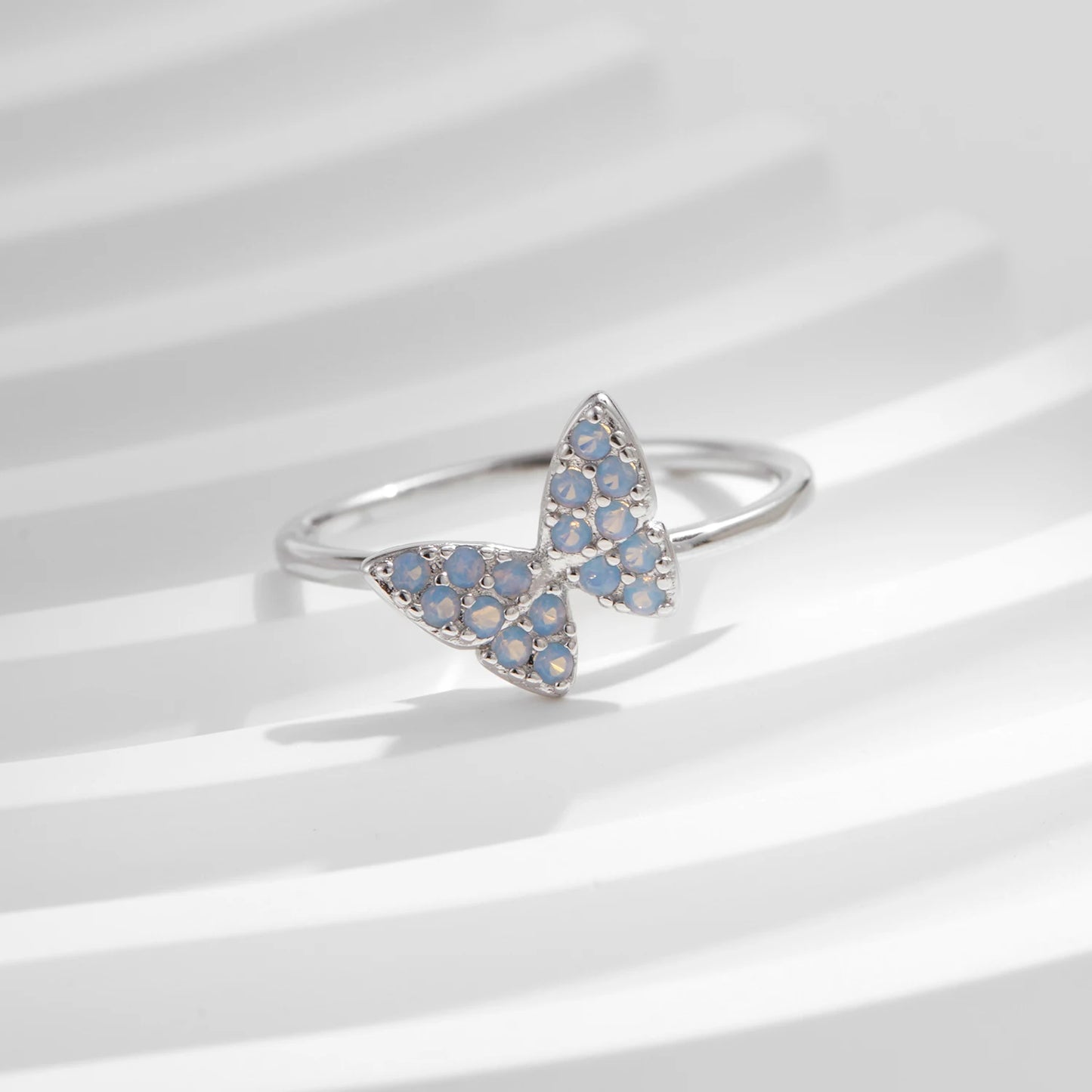 Sterling silver ring with a delicate butterfly shape inlaid with shimmering opal stones

