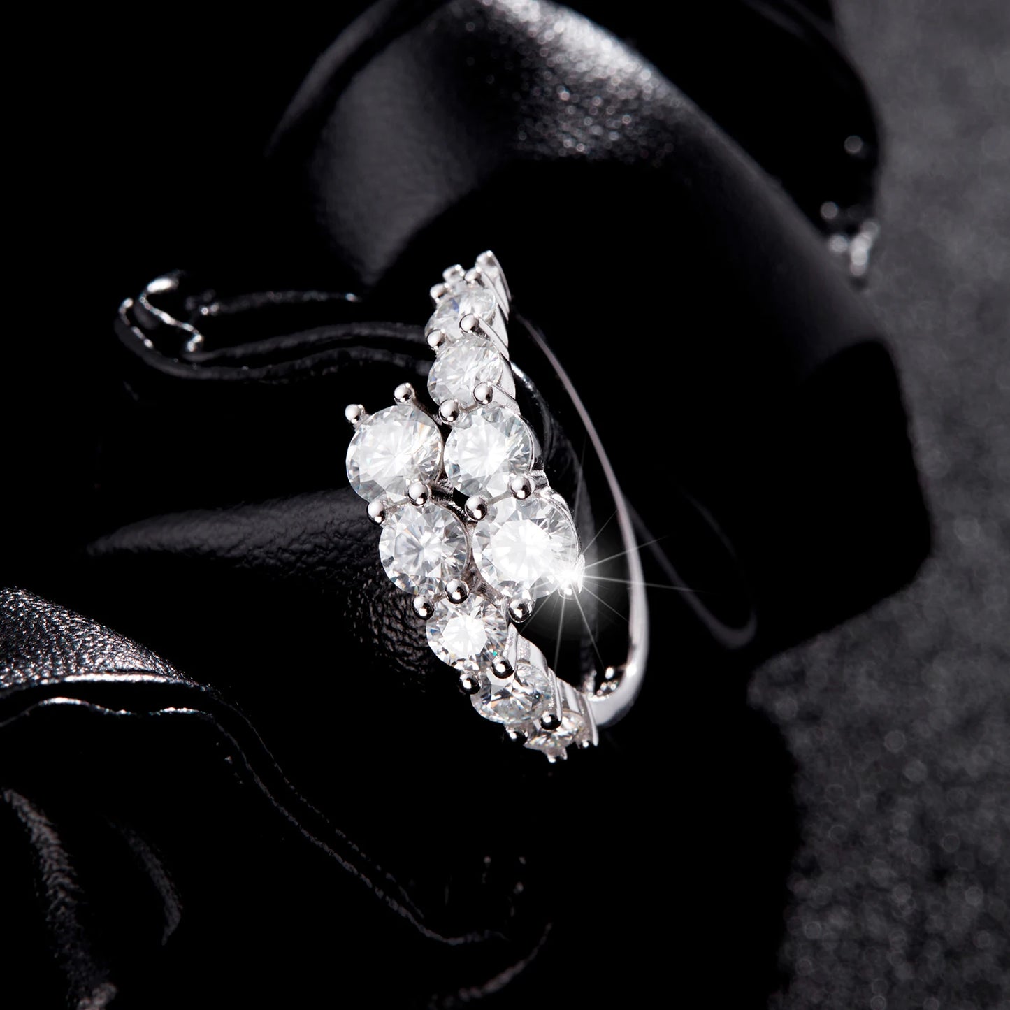 Sterling silver ring with a diagonal cluster of brilliant white round-cut stones in a cascading arrangement

